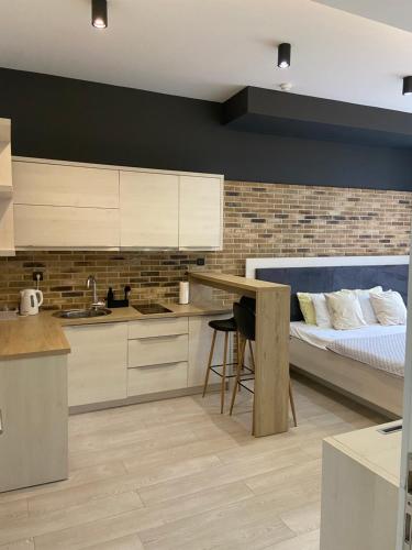 a kitchen with a bed and a desk with a table at Boulevard Apartments in Sarajevo