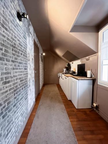 a kitchen with a brick wall and white cabinets at Givernel in Giverny
