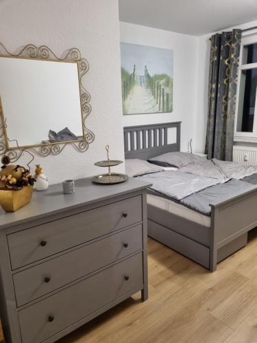 a bedroom with a bed with a dresser and a mirror at Ferienwohnung im Villenviertel Ilmenau in Ilmenau