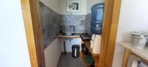 a small kitchen with a sink in a room at Cabaña Coliumo Tomé in Dichato