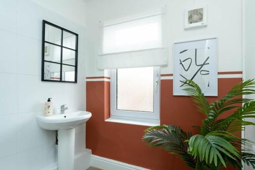 a bathroom with a sink and a window at NEW DEALS - Spacious, Stylish Home - Wi-Fi, Smart TV, Parking & Outdoor Area in Leicester