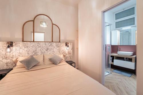 a bedroom with a bed with a mirror and a sink at Elegant design apartment in historical city center in Catania