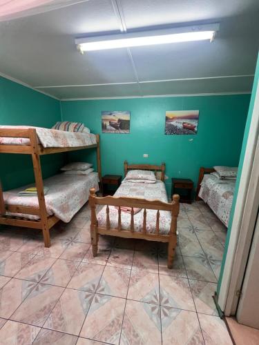 a room with three bunk beds and a tiled floor at HOSPEDAJE BETTY in Punta Arenas
