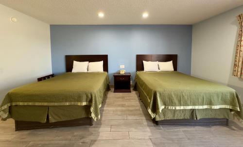 two beds sitting next to each other in a room at Razorback Inn in Rogers