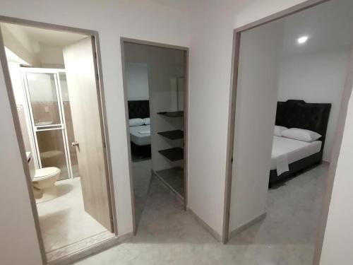 a bathroom with a mirror and a bedroom with a bed at Apartamento de 3 HABITACIONES en Bucaramanga in Bucaramanga