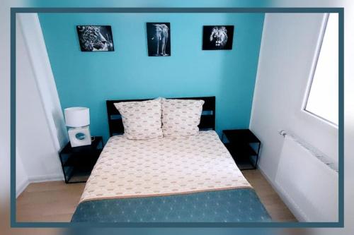 - une chambre dotée d'un lit avec 3 photos sur le mur dans l'établissement Logement 6 pers. Tout équipé, à Montluçon