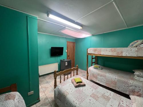 um quarto com 2 beliches e uma televisão em HOSPEDAJE BETTY em Punta Arenas