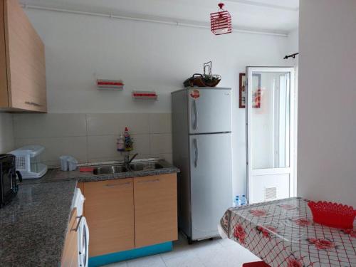 uma cozinha com um frigorífico branco e um lavatório em Résidence Sayadi - Chatt Meriam - Sousse em Port El Kantaoui