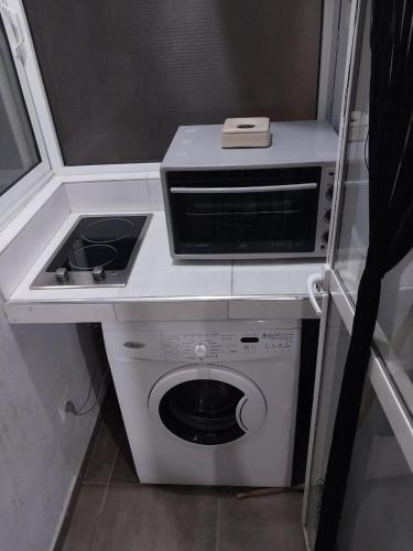 uma pequena cozinha com um fogão e uma máquina de lavar roupa em Bel appartement de 54 M² bien meublé situé au coeur de Marrakech et à proximité de toute commodité em Marrakech