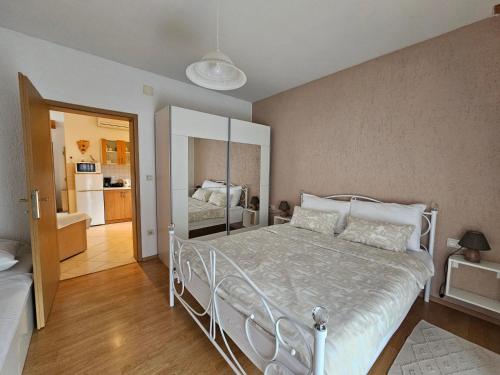 a bedroom with a white bed and a bathroom at Apartments & rooms MIKLEUS in Mošćenička Draga