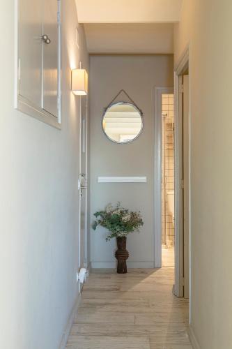 a hallway with a potted plant and a mirror at Casa Concha Apartamentos in Calella de Palafrugell