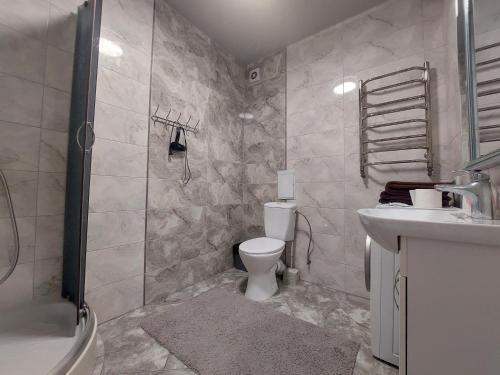 La salle de bains est pourvue de toilettes, d'un lavabo et d'une douche. dans l'établissement Апартаменти в новобудові, à Kulʼparkuv