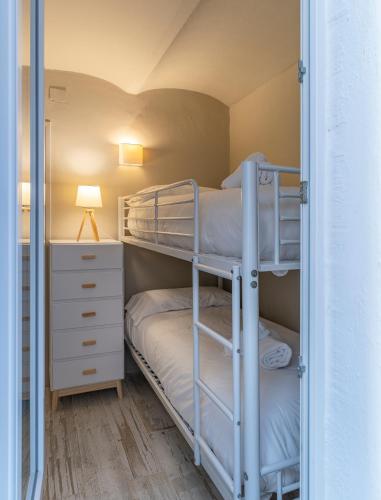 a bunk bed room with two bunk beds and a desk at Casa Concha Apartamentos in Calella de Palafrugell