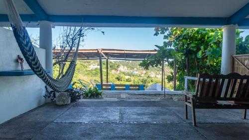 a patio with a hammock and a bench in a room at Posada Arigalan in Mazunte
