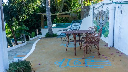 a table and chairs with graffiti on the ground at Posada Arigalan in Mazunte