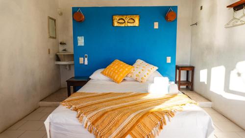 a bedroom with a blue wall and a bed at Posada Arigalan in Mazunte