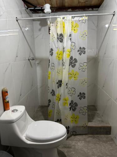 y baño con aseo y cortina de ducha. en CABAÑA RIO ATULAPA #1 en Esquipulas