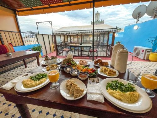 una mesa de madera con platos de comida. en Riad Merzouga en Fez