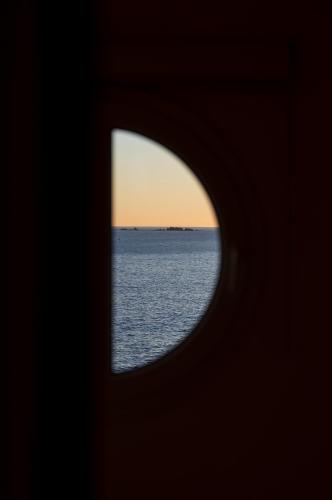 a view of the ocean through a hole in a building at Casa Concha Apartamentos in Calella de Palafrugell
