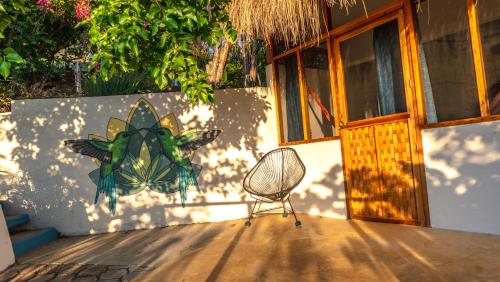 a chair sitting on a porch next to a building at Posada Arigalan in Mazunte