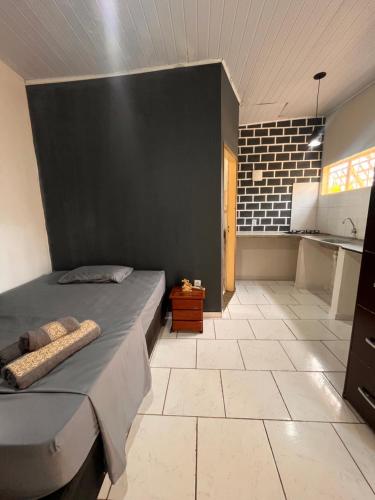 a bedroom with a bed and a black wall at Chale do Japa in Sao Jorge