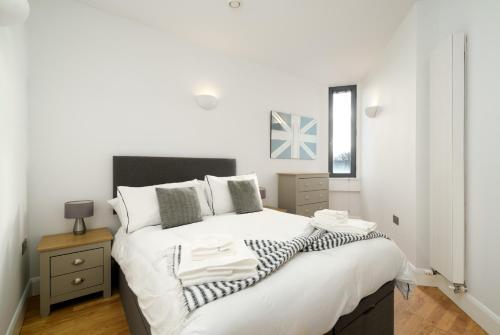 a bedroom with a large bed with white sheets and pillows at Luxury Central London Penthouse in London