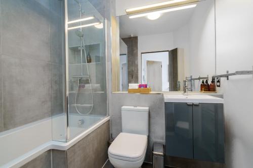 a bathroom with a toilet and a shower and a sink at Luxury Central London Penthouse in London