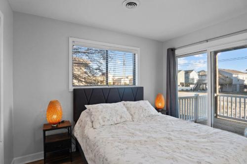 a bedroom with a bed and a large window at 5310 - Wright by the Beach by Resort Realty in Kill Devil Hills