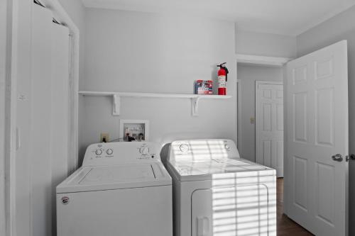 a white laundry room with a washer and dryer at 5310 - Wright by the Beach by Resort Realty in Kill Devil Hills