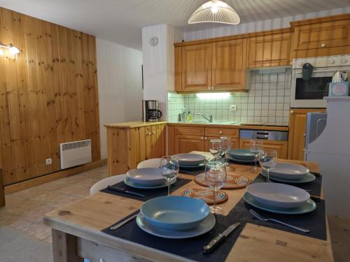 une cuisine avec une table avec des assiettes et des verres à vin dans l'établissement Appartement Cosy avec Terrasse et Garage, aux Houches
