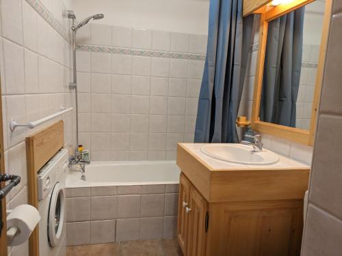 a bathroom with a sink and a washing machine at Appartement Cosy avec Terrasse et Garage in Les Houches