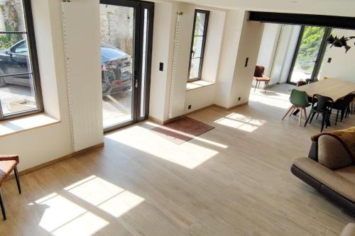 a living room with a table and some windows at GÎTE Les Cigognes N0ires in Dragey