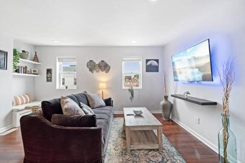 a living room with a couch and a table at Double Decker Roofdeck Gorgeous View in Passyunk in Philadelphia
