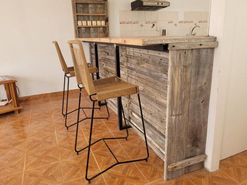 a kitchen with a wooden counter with two chairs at Hostel Tierra Patagónica in Perito Moreno