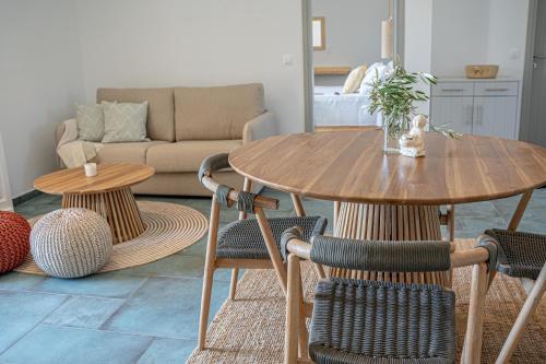 a living room with a wooden table and chairs at Olive Tree Homes in Ios Chora