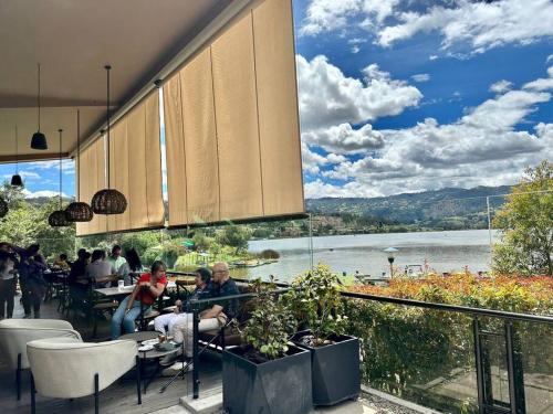 een groep mensen in een restaurant met uitzicht op een meer bij paipa casa bonita in Paipa