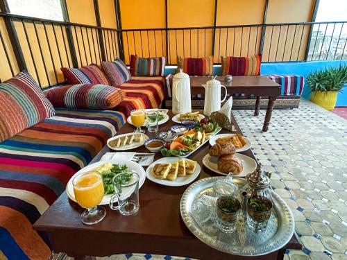 una mesa con platos de comida y bebidas. en Riad Merzouga en Fez