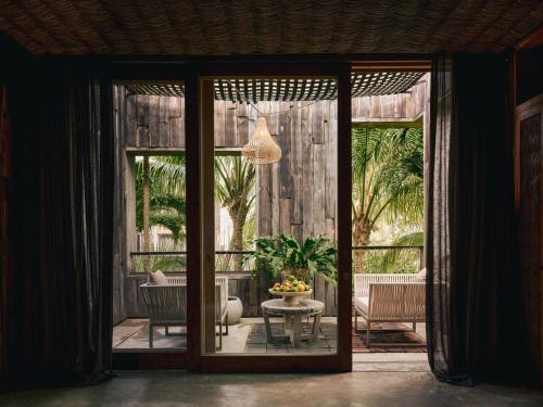 a room with a patio with a table and chairs at BE Destination Tulum in Tulum