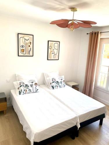 une chambre avec un grand lit blanc avec un ventilateur de plafond dans l'établissement Les Terrasses des Antiques, à Saint-Rémy-de-Provence