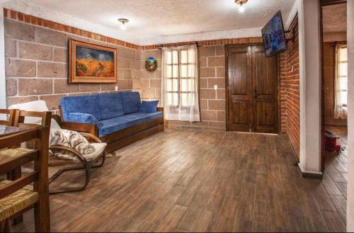 Alcocer的住宿－Finca La Martina，客厅设有蓝色的沙发和砖墙