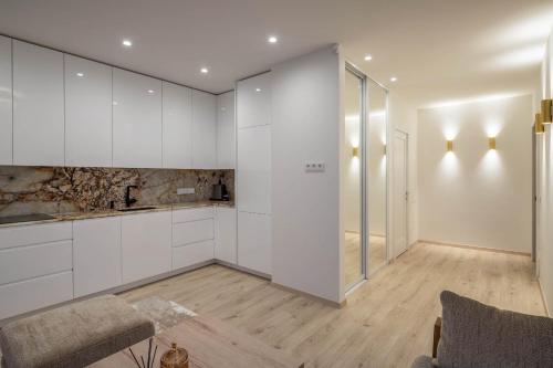 a kitchen with white cabinets and a glass door at Brand new home in the center of the Old Town in Klaipėda