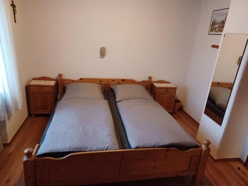 a small bedroom with two beds and a mirror at Zum Bergbauern in Waidhaus