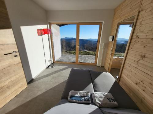 a living room with a couch and a large window at Haus am Hochwechsel in Breitenbrunn