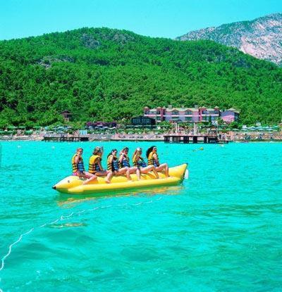 a group of people riding on a yellow raft in the water at Seagull Hotel in Beldibi