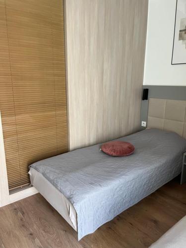 uma cama com uma almofada vermelha num quarto em Studio Wolska 165 Apartament em Varsóvia