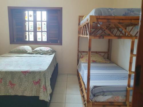 Ένα ή περισσότερα κρεβάτια σε δωμάτιο στο CASA ACONCHEGANTE TEMPORA CARAGUATATUBA