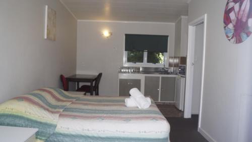 a hotel room with a bed and a kitchen at Apple Motor Inn in Hastings