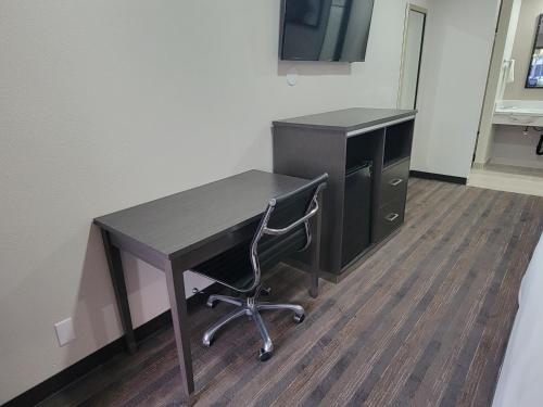 a desk with a computer and a chair in an office at Travelodge by Wyndham Buena Park in Buena Park