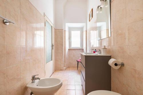 een badkamer met een wastafel, een toilet en een spiegel bij La Casa di Beppe in Piombino