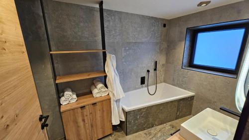 a bathroom with a shower and a tub and a sink at Apartment Gosauschmied in Gosau